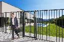 VTC-RAIL_LMKQV2_SHKL_TRICONE_PKWB2000__Man_holding_briefcase_black_fence_villa_with_pool__1920px.webp