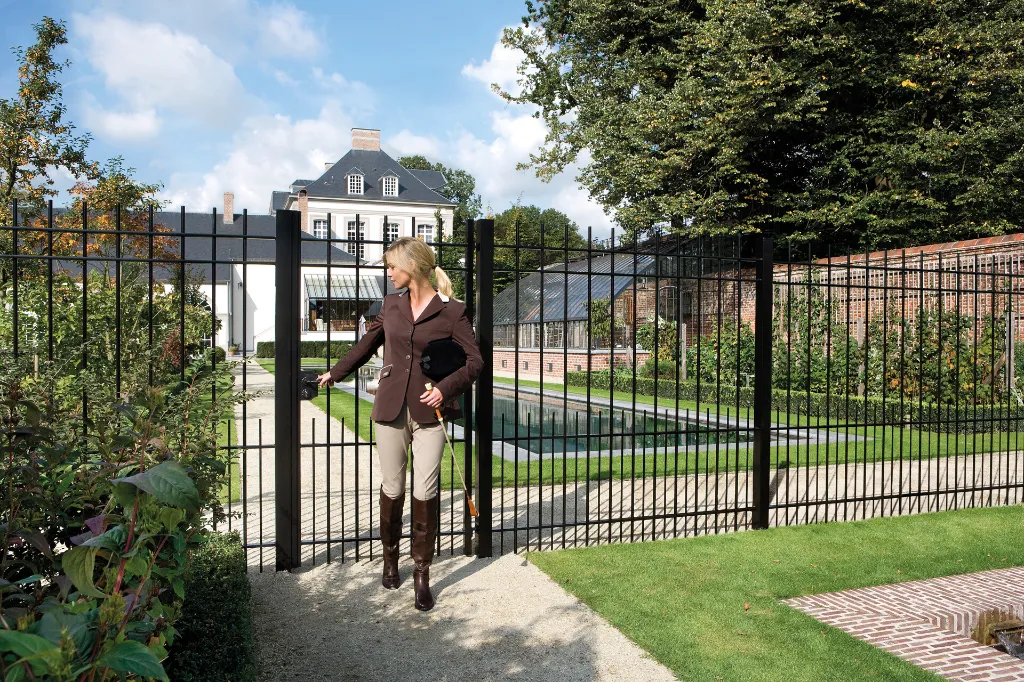 LAKQH2_GBMU18_SPKZ__Equestrian_leaving_black_ornamental_gate_at_villa__1920px.webp